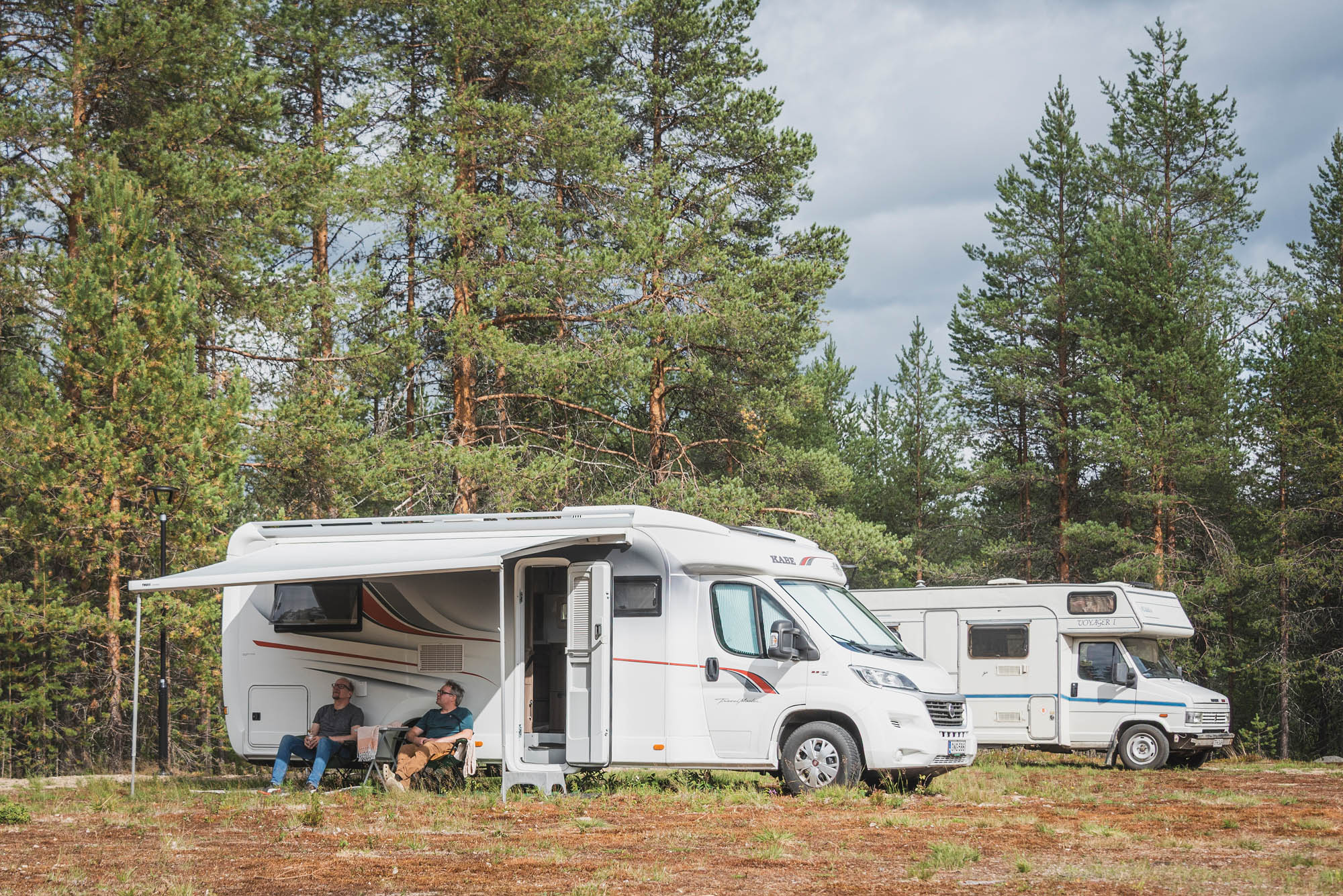 Caravans parked in a peaceful lakeside forest at Lehtiniemi Guesthouse, Posio, Finnish Lapland.